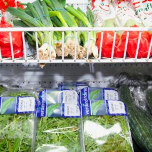Leafy greens presented on supermarket produce shelving